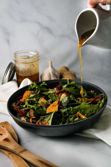 miso vinaigrette poured on a salad