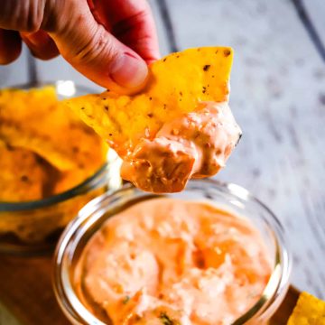 hand dipping a chip into kimchi dip