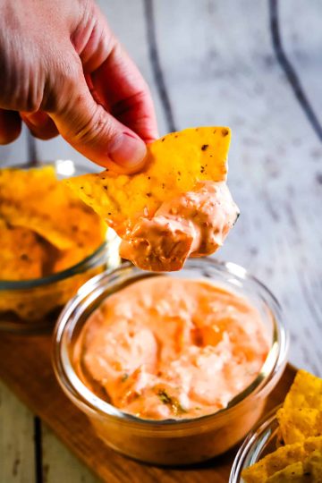hand dipping a chip into kimchi dip