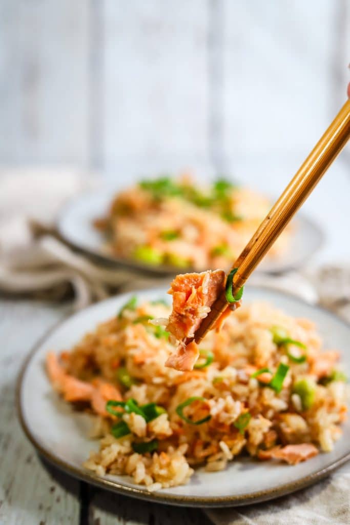 chopsticks picking up a piece of salmon